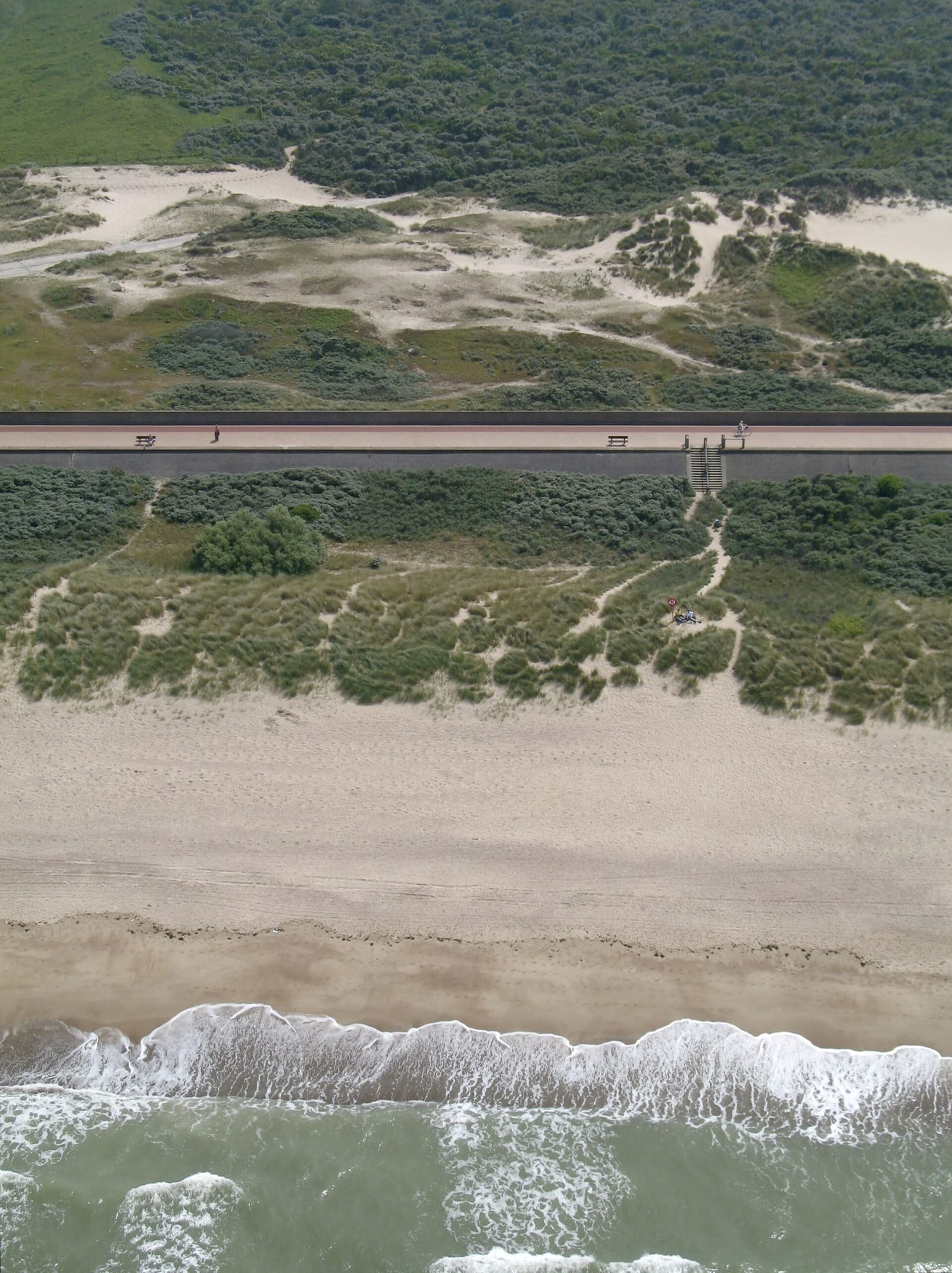 Aerial view of the dunes, promenade and breaking North Sea waves at Knokke on the Belgian coast.
