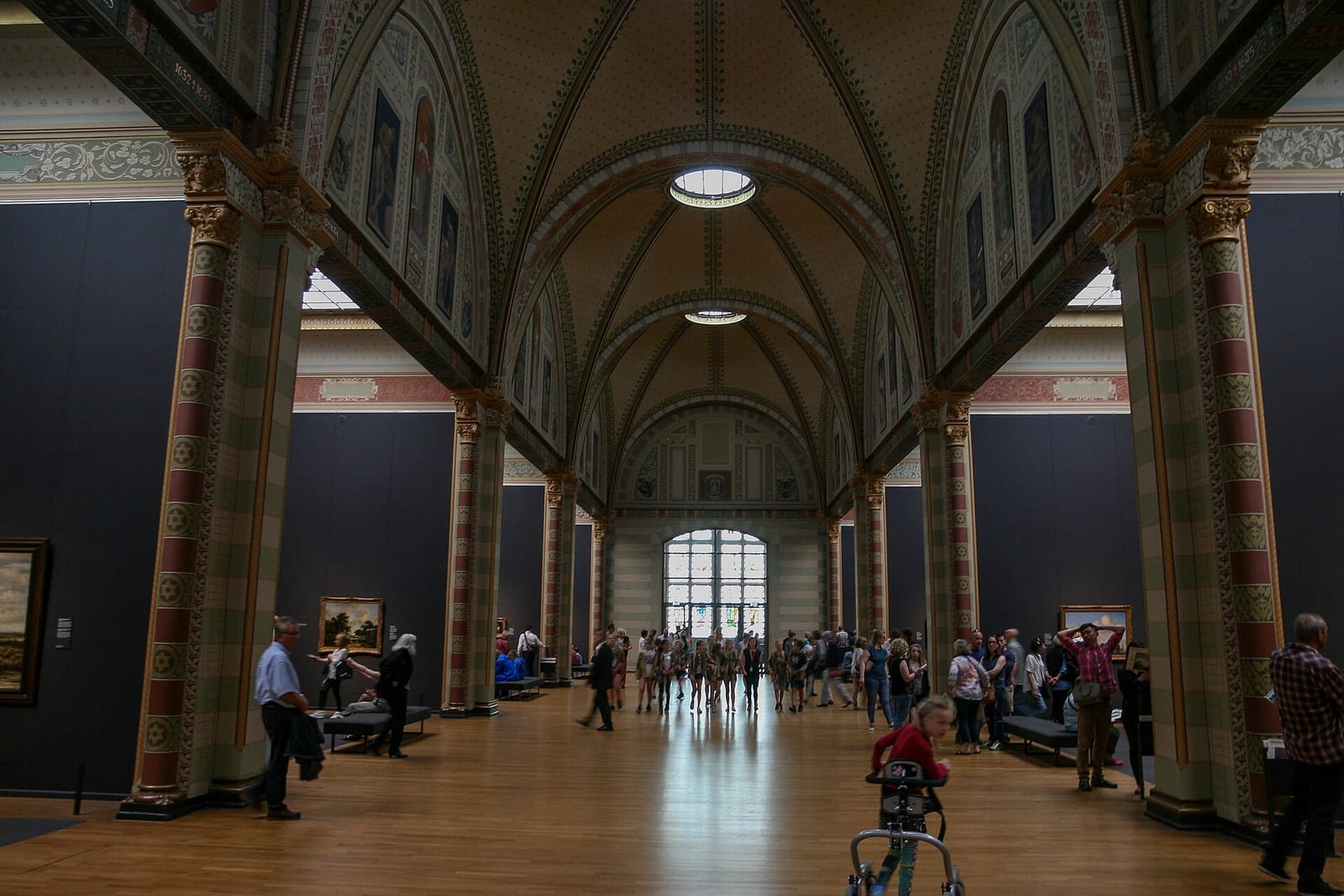 Visitors in the vaulted Gallery of Honour of the Rijksmuseum in Amsterdam, with Golden Age paintings hung in the side alcoves.