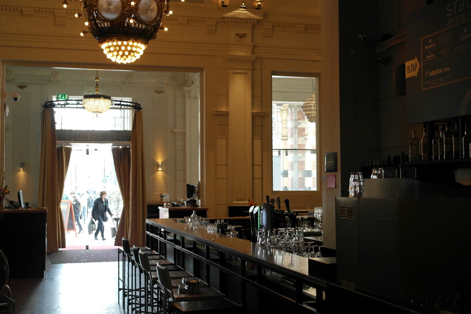 The long bar and tall windows of café-restaurant Stanislavski on the ground floor of the Stadsschouwburg theatre in Amsterdam.