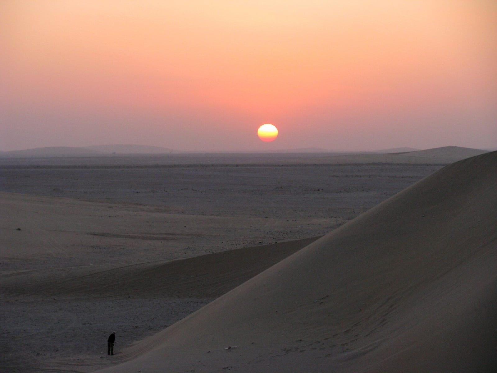 Sunset over the sand dunes of the Qatari desert, the sky shading from orange to violet, January 2009.