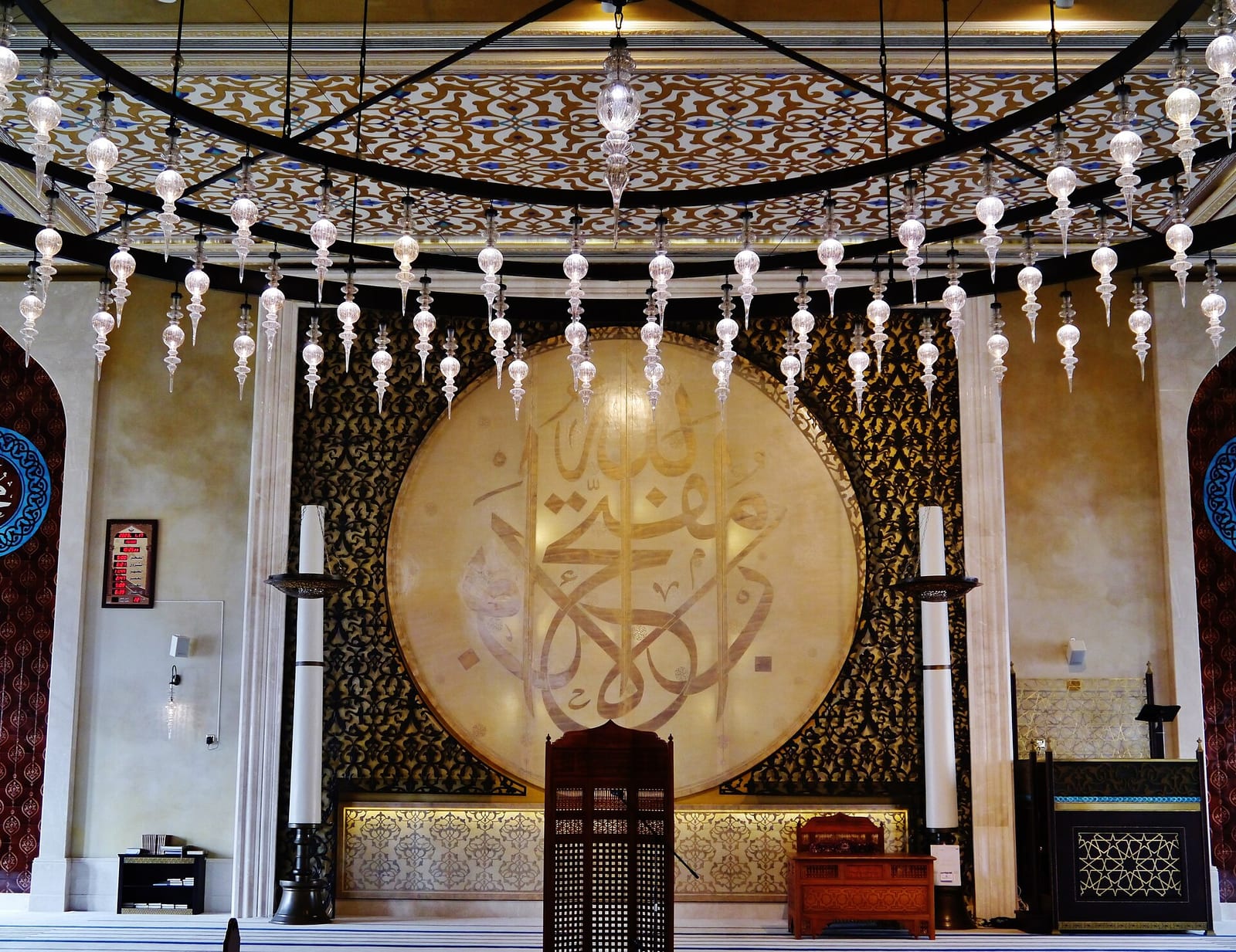 Turquoise, blue and gold tiled interior of the Katara Mosque in Doha with calligraphic bands and geometric panels, January 2023.