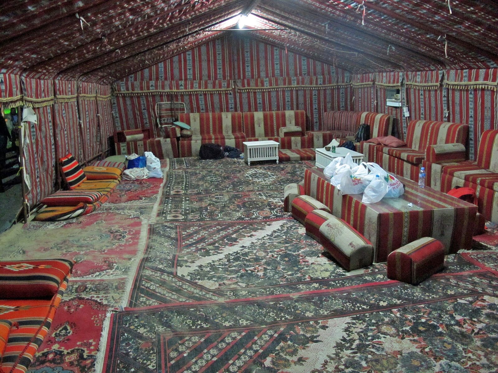 Interior of a Qatari tent majlis in southern Qatar with floor cushions and patterned carpets arranged around the walls, 2011.