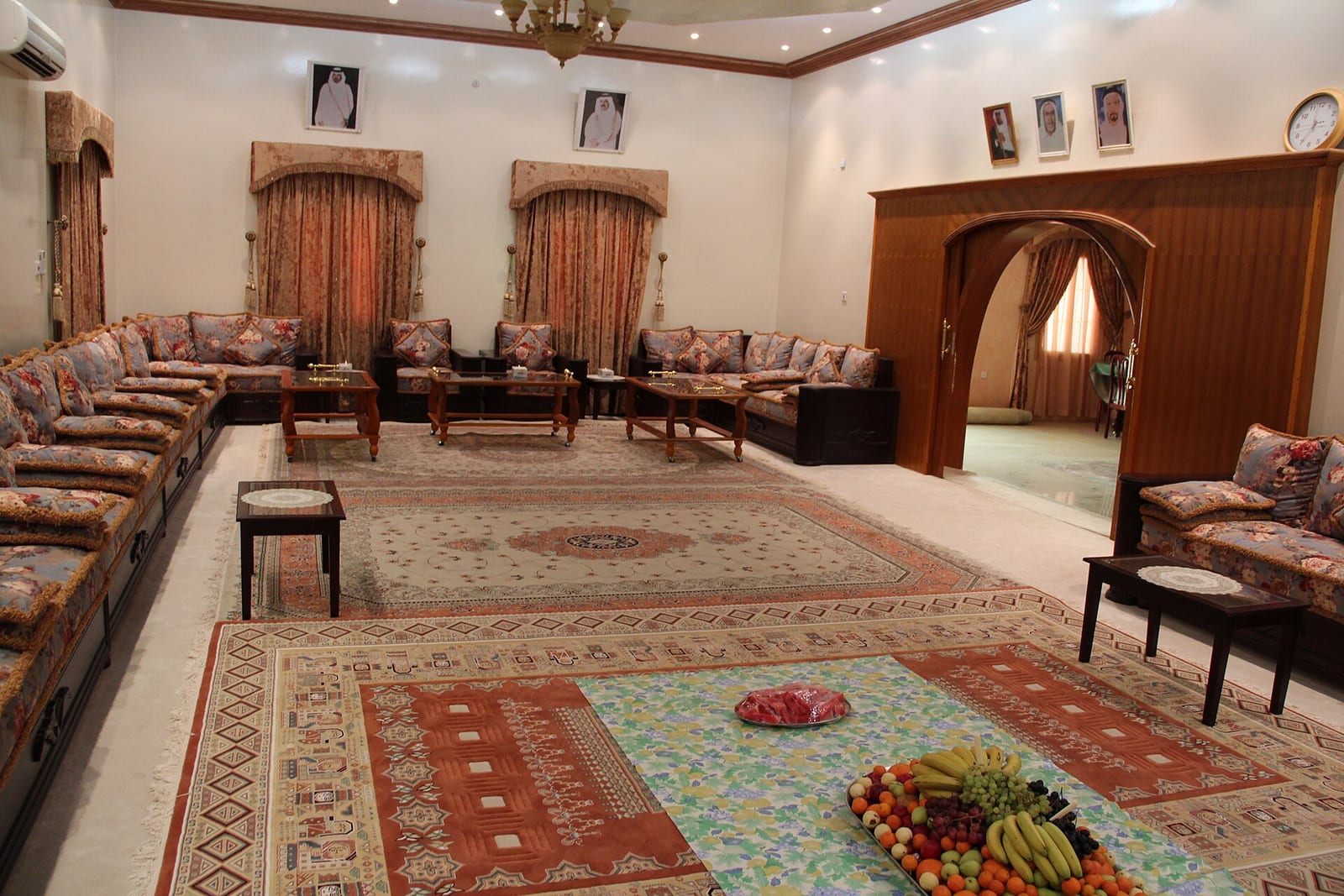 Heritage majlis in northern Qatar with low seating along the walls and framed portraits of the rulers hung above, April 2012.