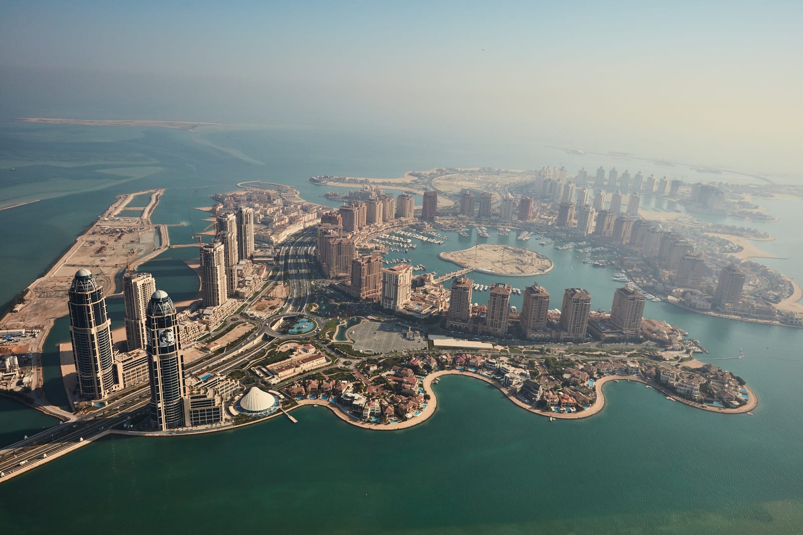 Aerial view of the whole artificial island of The Pearl-Qatar with its marinas, canals, towers and villa precincts.