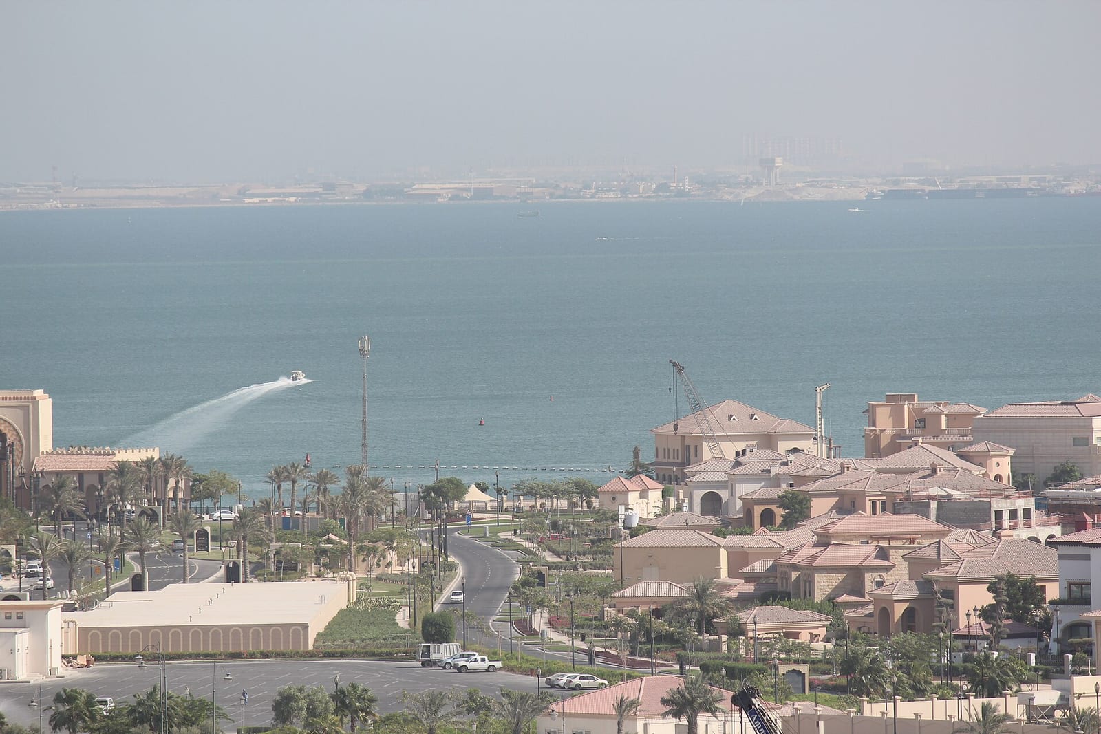 Terracotta-roofed, sand-rendered Mediterranean-style villas on The Pearl-Qatar seen across the water in September 2014.