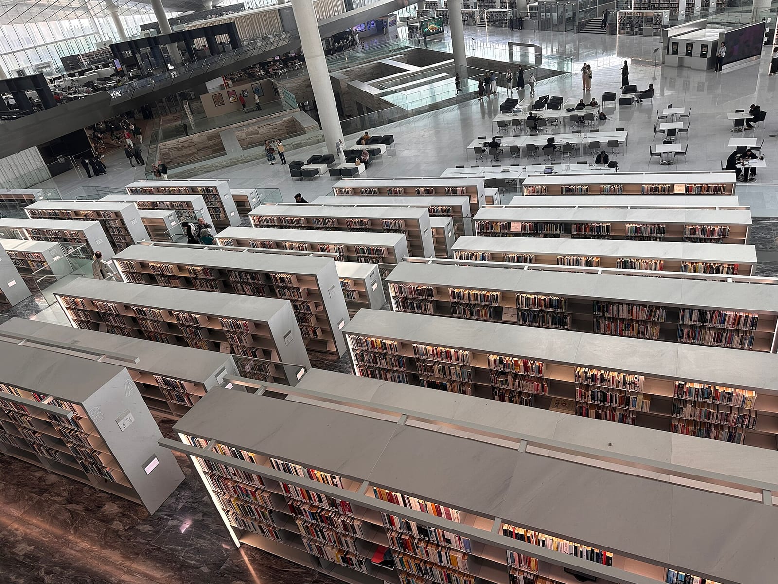 Stepped white reading terraces and bookshelves inside the Qatar National Library in Education City, February 2026.
