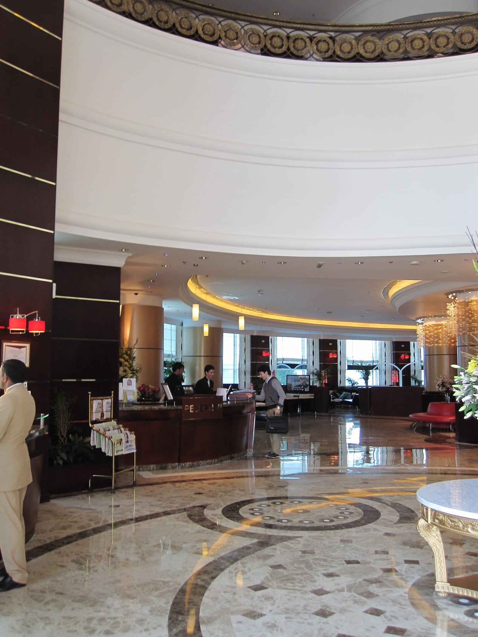 Double-height lobby of the Retaj Al Rayyan hotel in Doha with a central chandelier and marble floor, October 2011.
