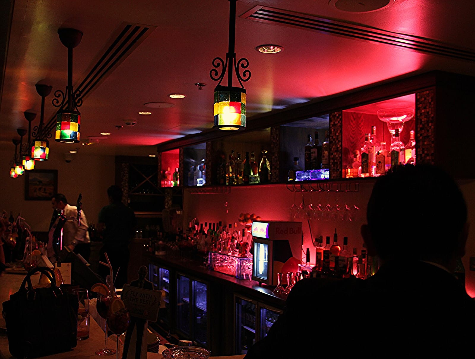 Low-lit bar interior inside the Sheraton Grand Doha with warm timber, upholstered seating and pendant lights, October 2013.