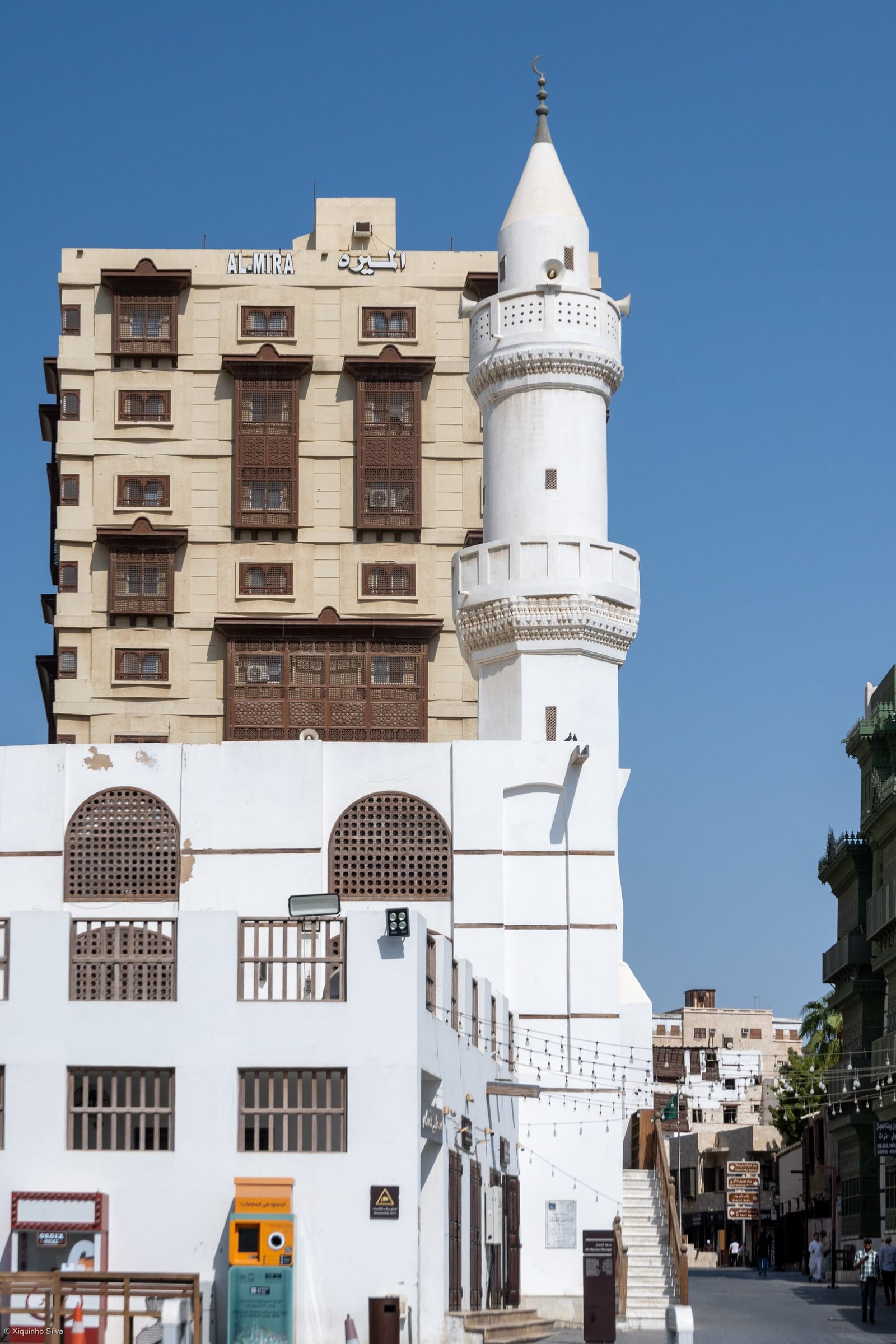 Tall coral-stone tower house in Historic Jeddah with projecting wooden roshan balconies, September 2025.
