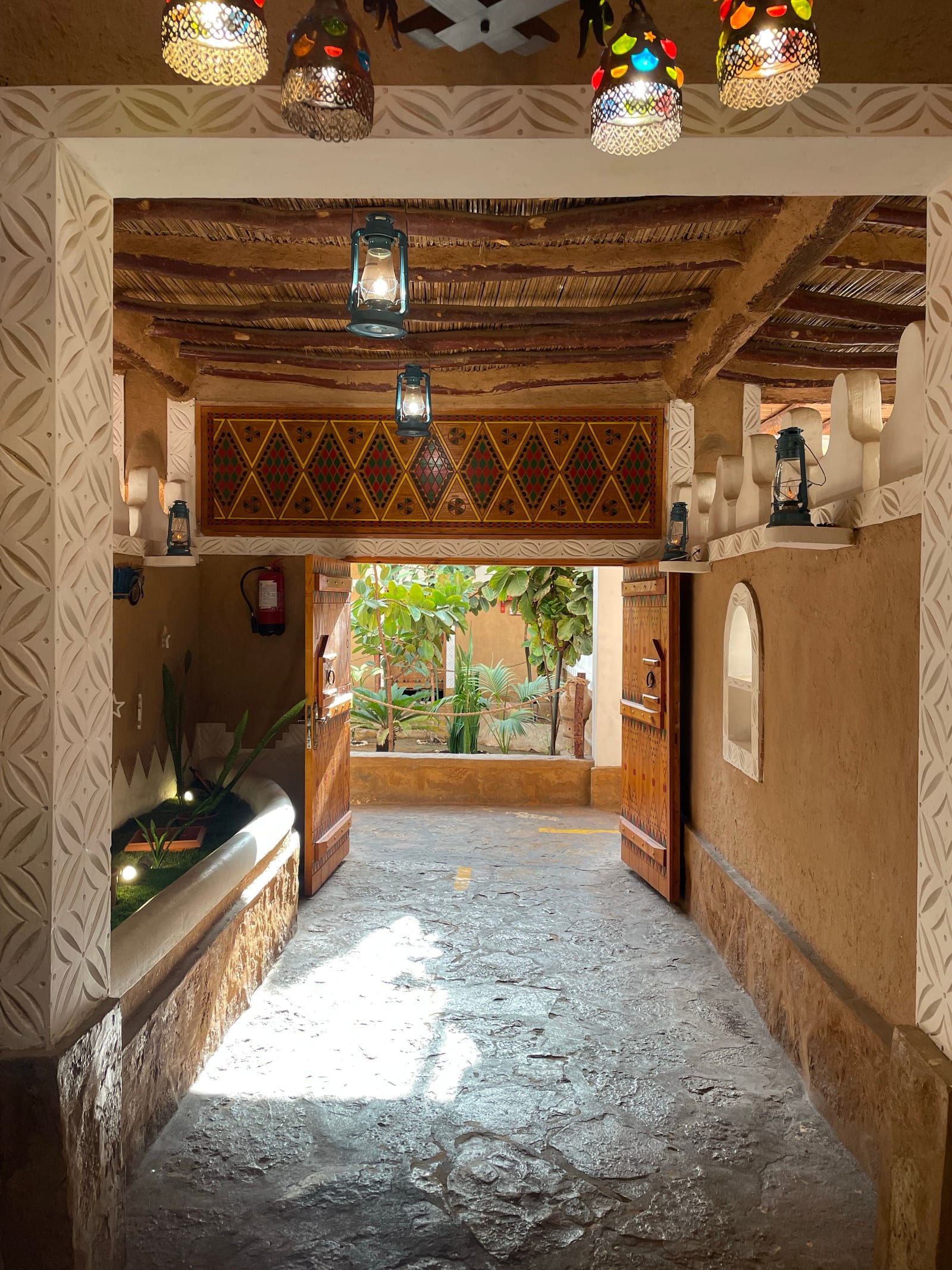 Heritage-style interior passage in Hafar Al Batin decorated with coloured lanterns and patterned textiles.