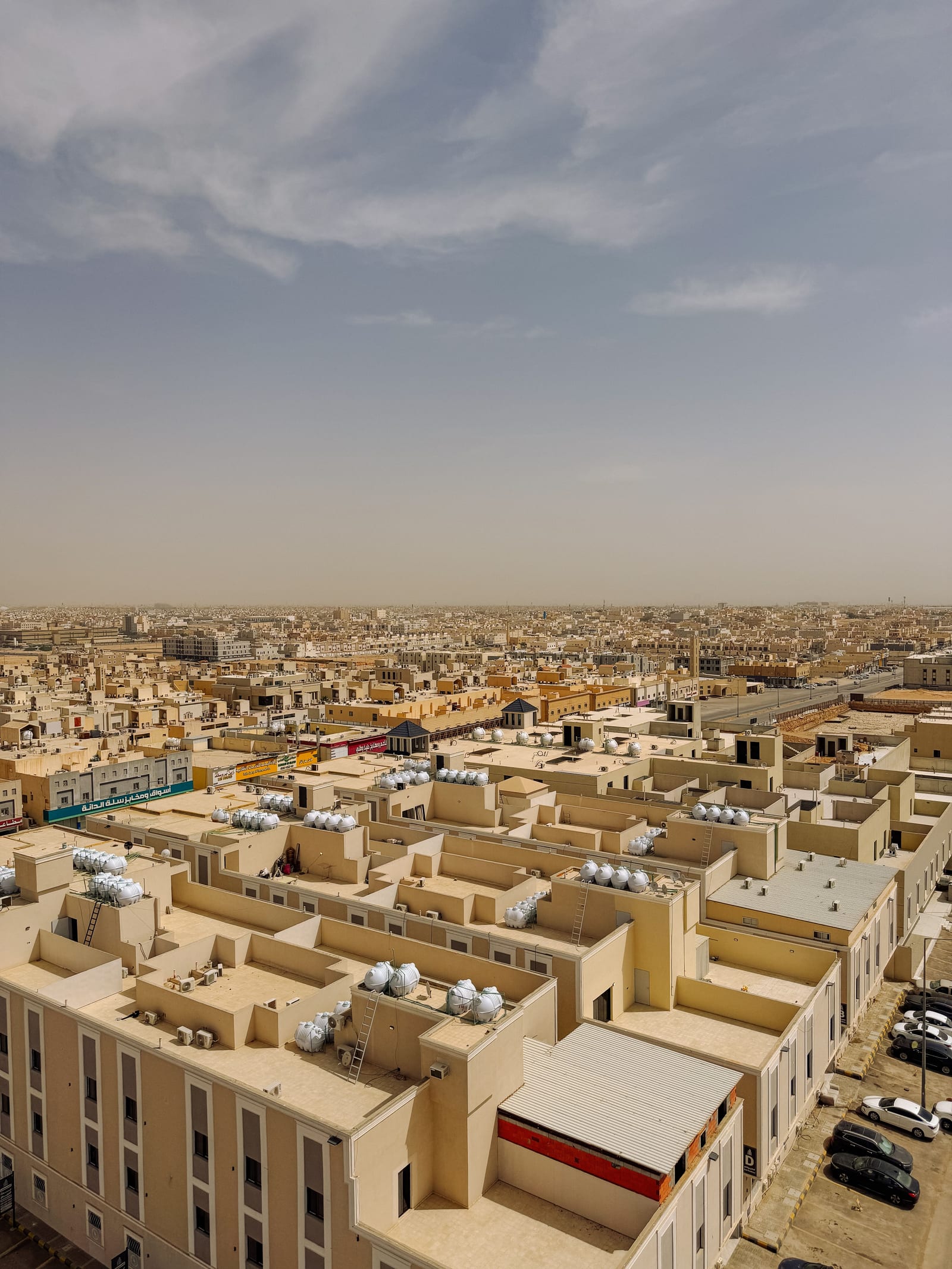 Aerial view of a Riyadh residential district of closely packed, flat-roofed villas and compound walls.