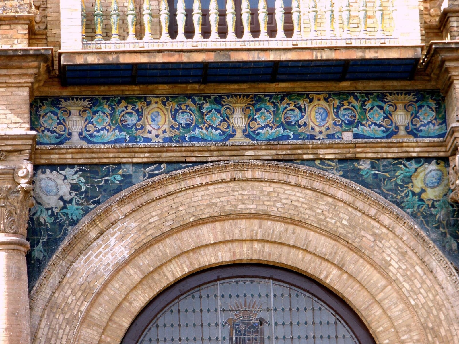 Painted azulejo tiles on the balustrade of the Plaza de España in Seville, blue and yellow ceramic on a sunny day.