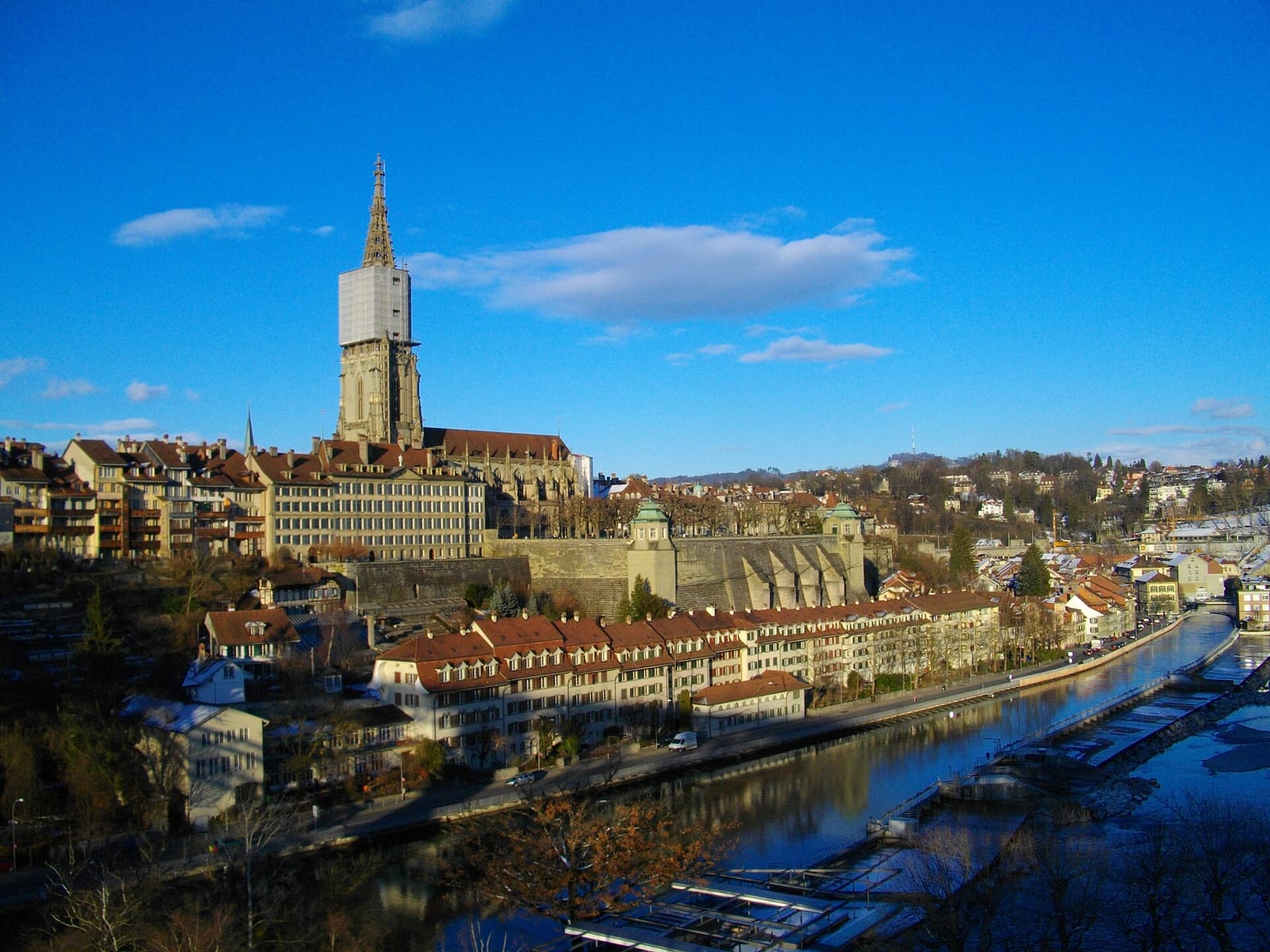 Bern's old town with the Münster tower and sandstone roofs above the Aare river, seen from the Kirchenfeld bridge.