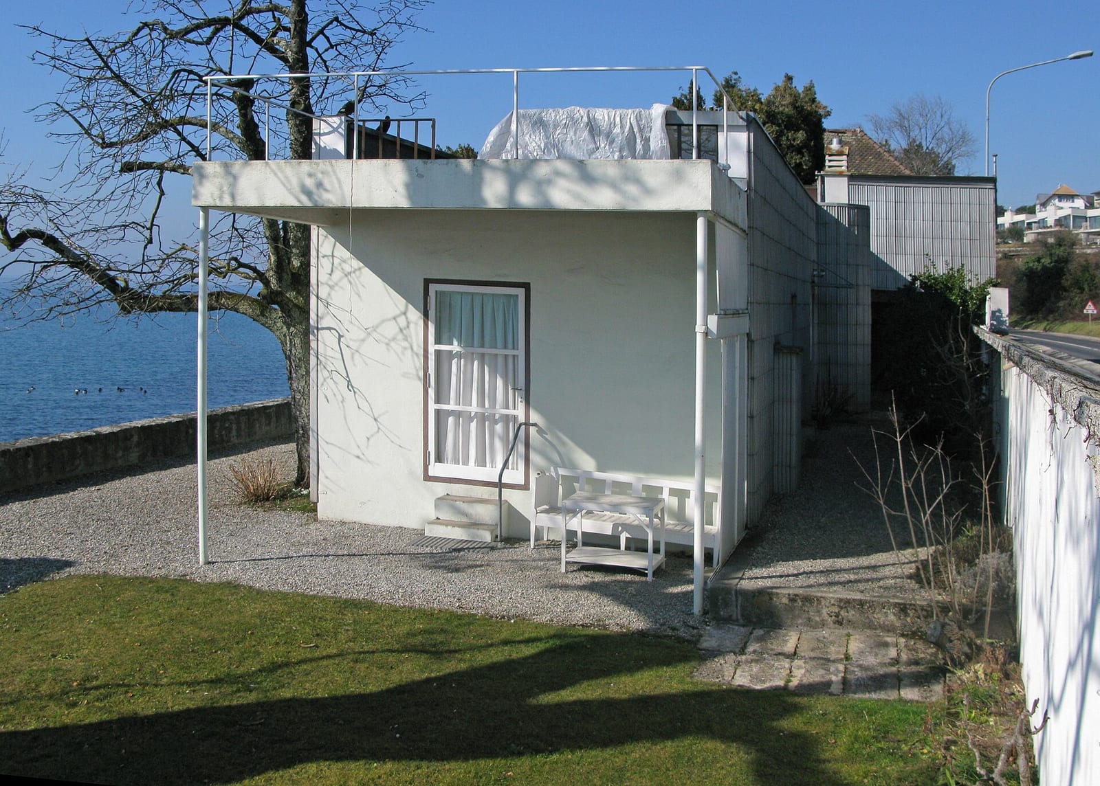 Le Corbusier's small white Villa Le Lac at Corseaux, its garden wall and terrace facing Lake Geneva in spring.