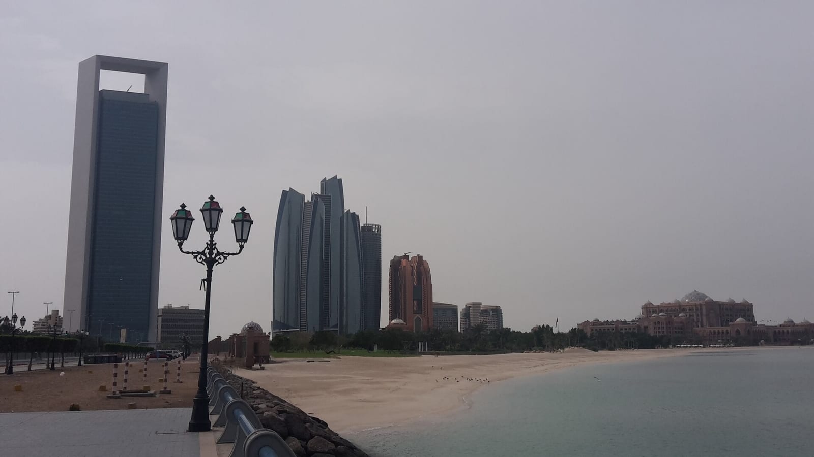Abu Dhabi skyline along the Corniche with the ADNOC headquarters, Etihad Towers and the Emirates Palace hotel in the foreground.