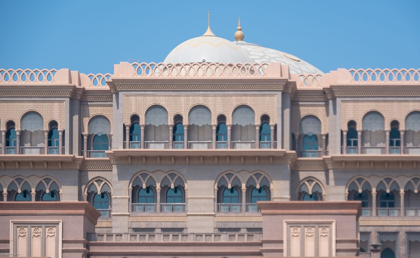 Emirates Palace hotel in Abu Dhabi, grand Arabian-style domes and arches in sand-coloured stone, photographed in daylight.