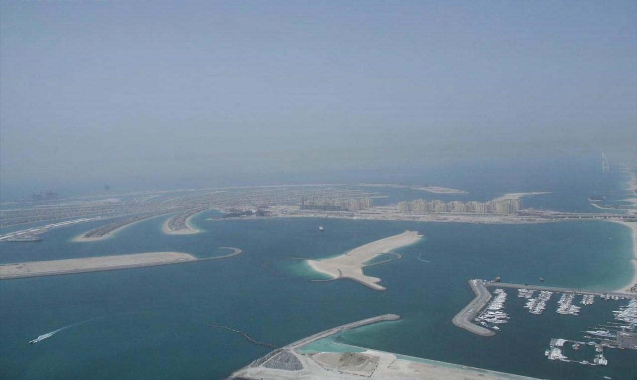 Aerial view of Palm Jumeirah in Dubai, villa fronds radiating from the trunk, the Burj Al Arab visible in the background, 2007.