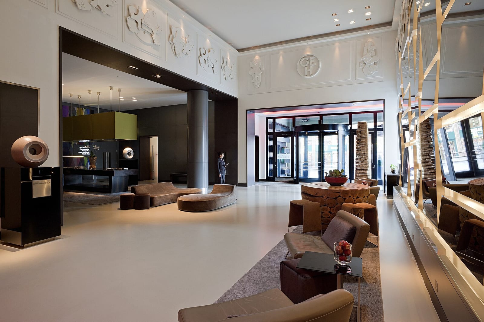 Lounge of the Andaz Liverpool Street hotel in London with seating, lamps and pictures on the walls.