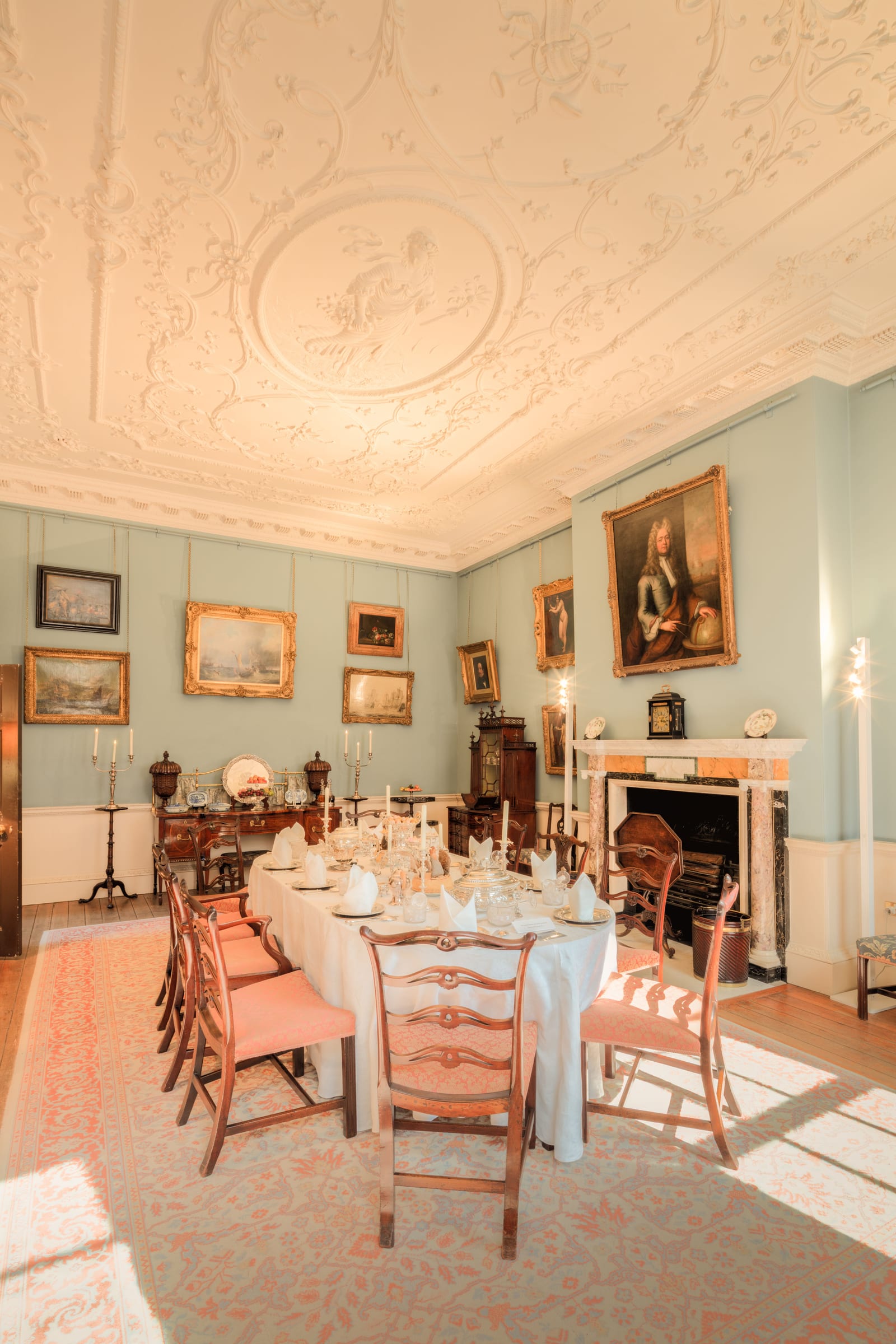 Historic dining room in an English country house near York with a long table and paintings on the walls.