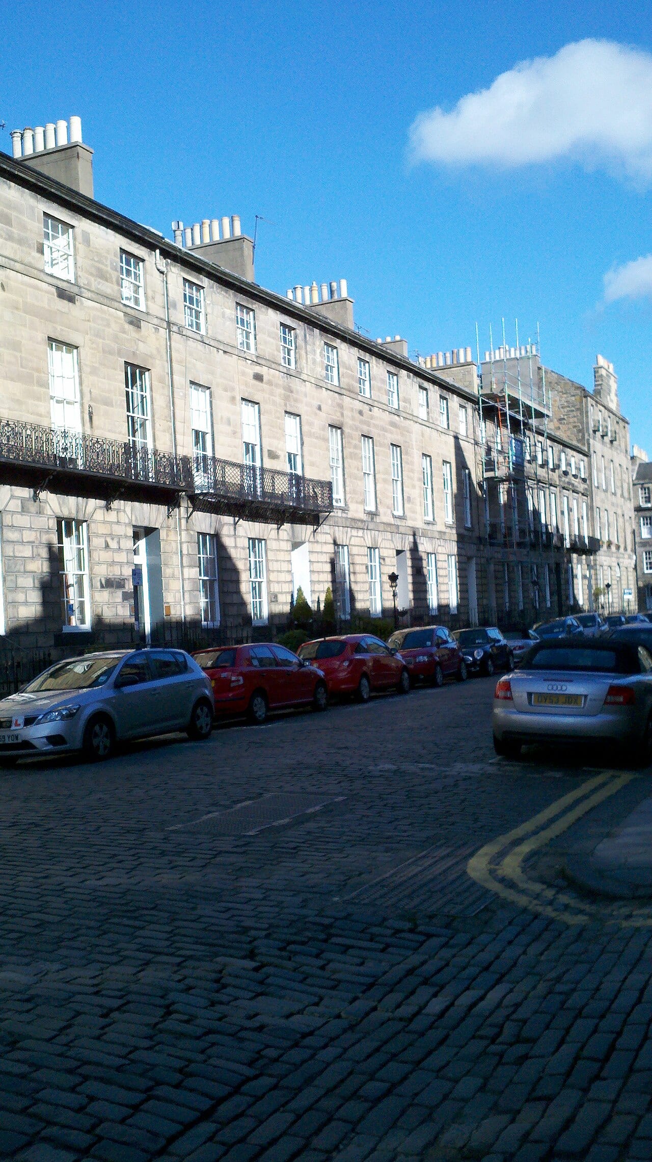 Grey sandstone Georgian terraced houses in Edinburgh's West End with tall sash windows.