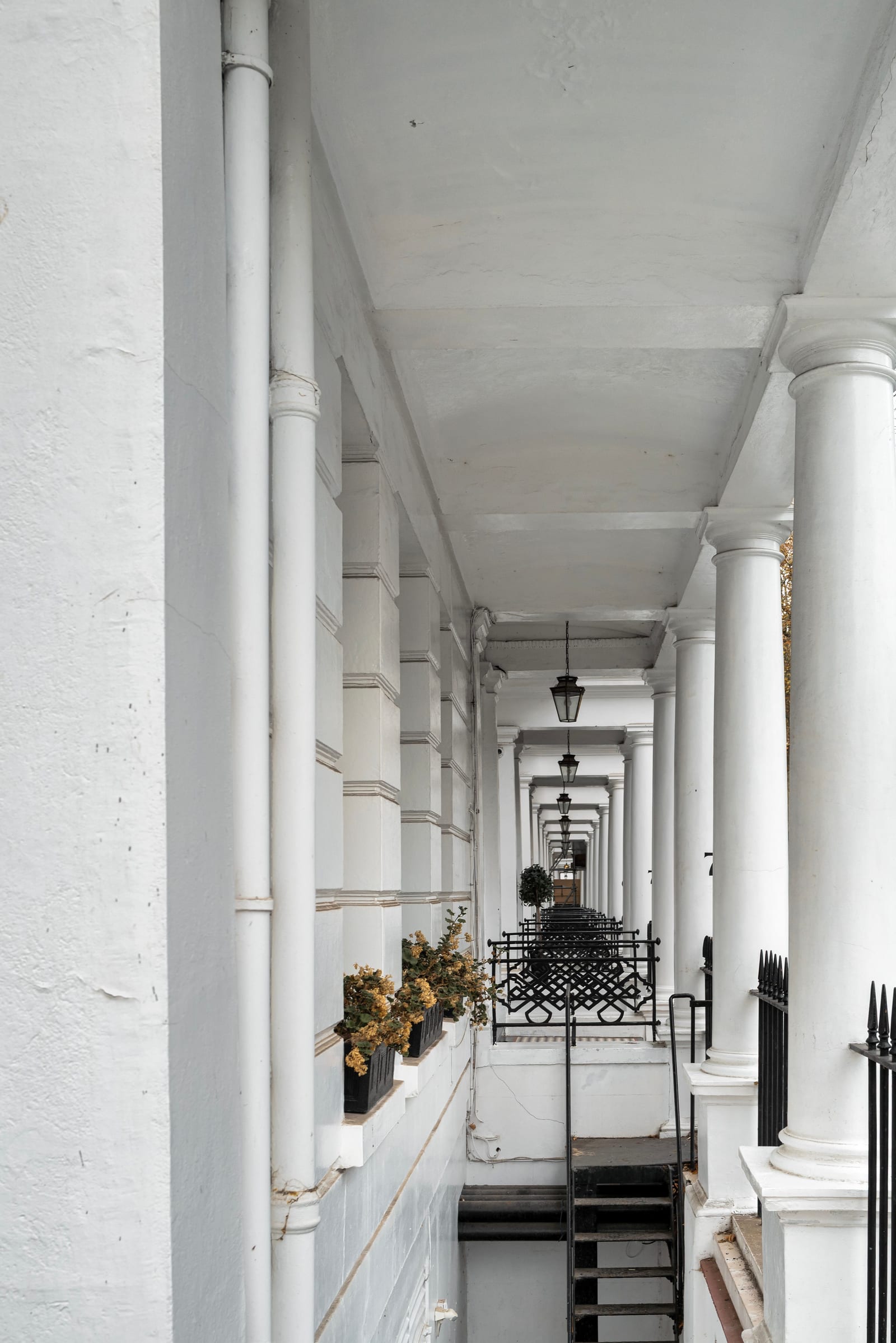Classical corridor with columns and pale walls in a South Kensington building, London.