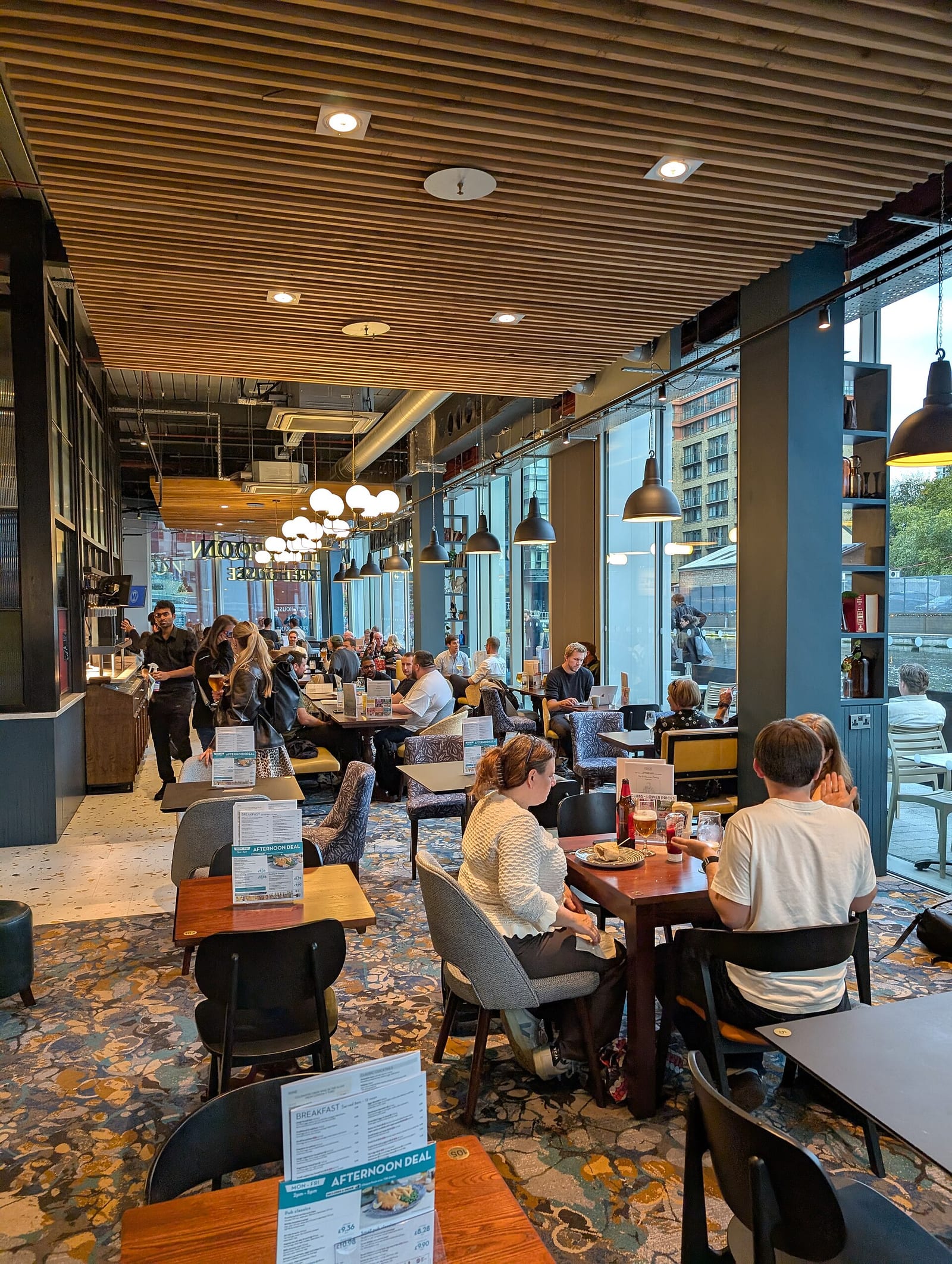 Interior of a London pub in Paddington with dark timber, a bar and framed pictures on the walls.