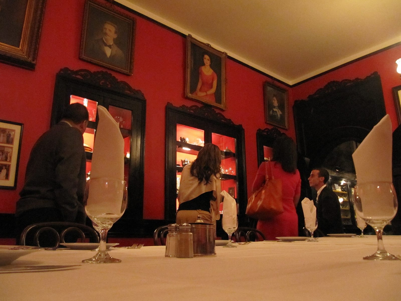 Proteus dining room at Antoine’s Restaurant, New Orleans, with white tablecloths and framed pictures on the walls.