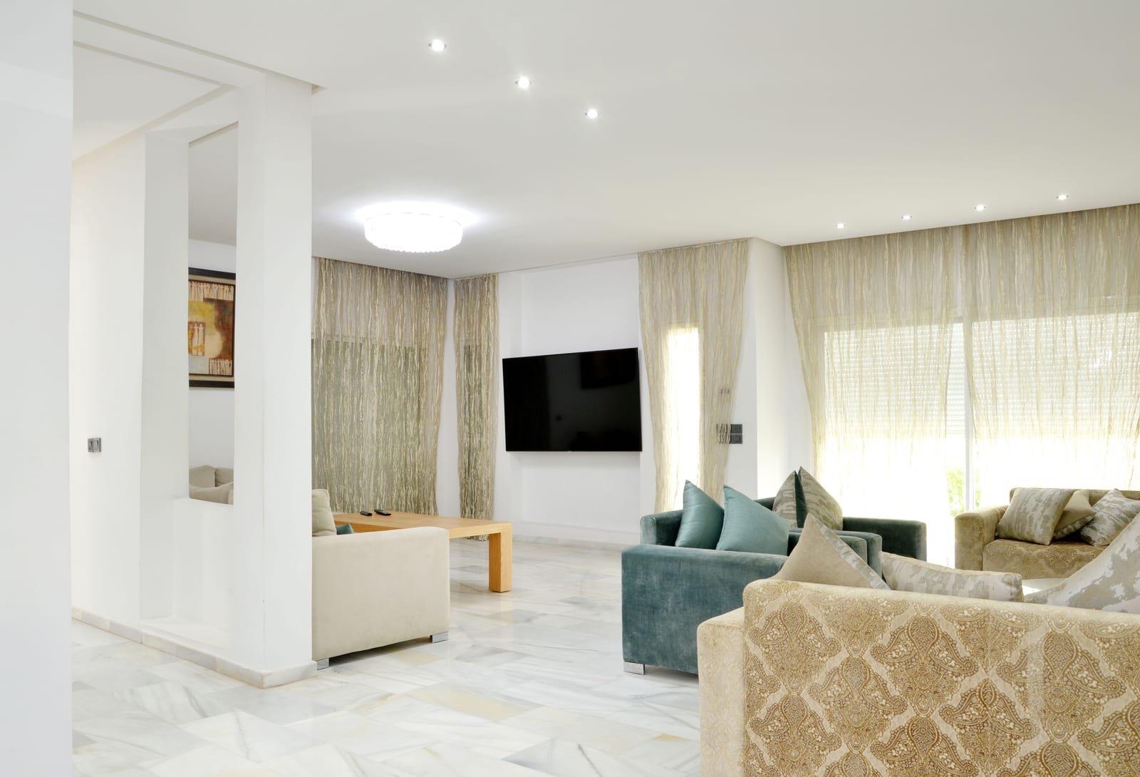 Spacious modern living room with large sofas, neutral decor and a high ceiling.