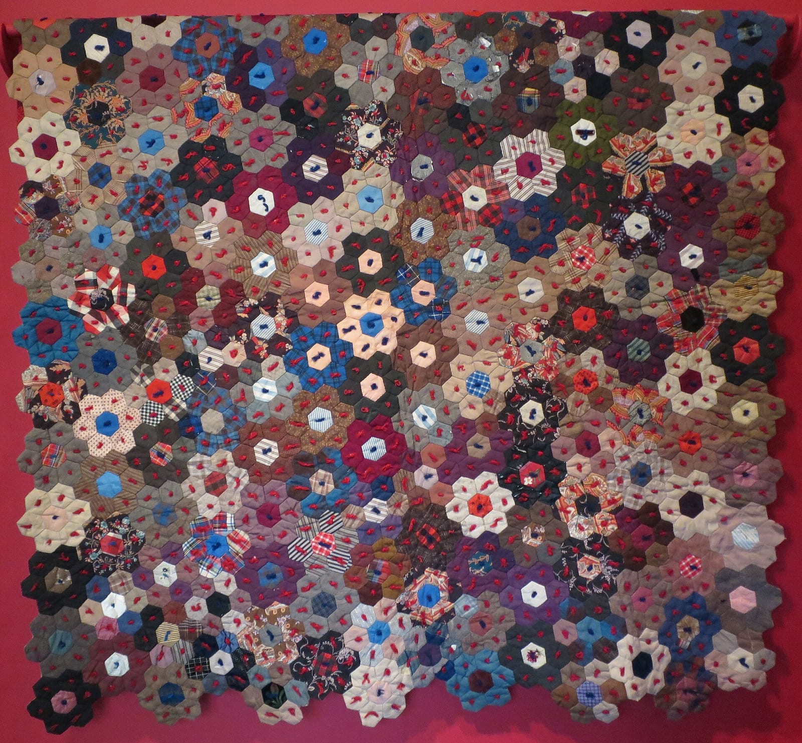 Nineteenth-century American pieced quilt in cotton, silk and wool with a bold geometric star pattern.