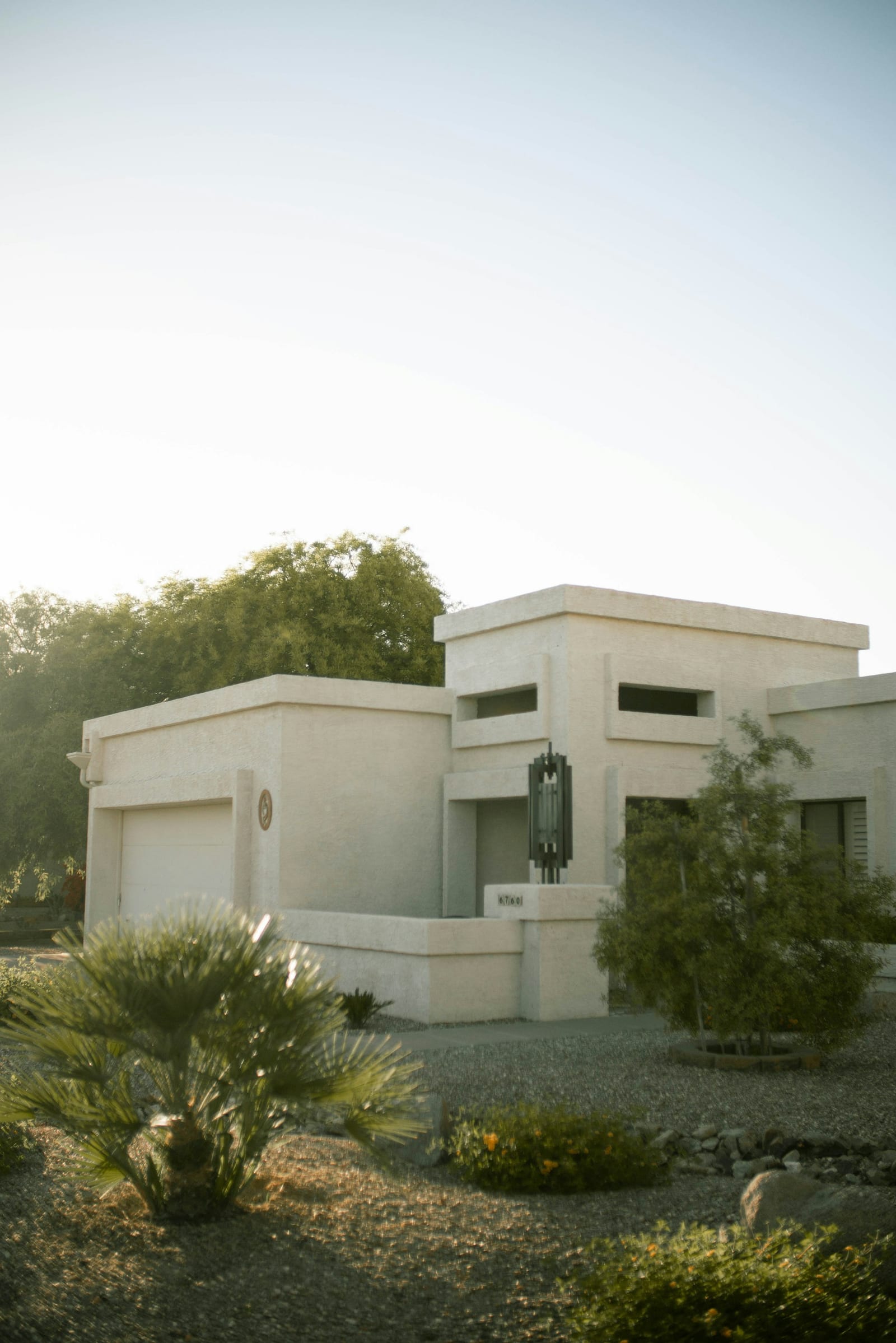 White contemporary desert house with flat roofs and a wide facade under a clear sky in Scottsdale, Arizona.