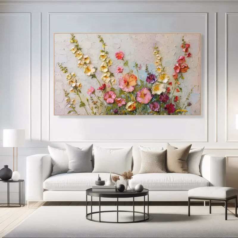 a wide horizontal sculpted flower painting of hollyhocks and wildflowers rising from the lower edge in pink, magenta, cream and yellow over a cracked white plaster ground, worked in thick raised relief