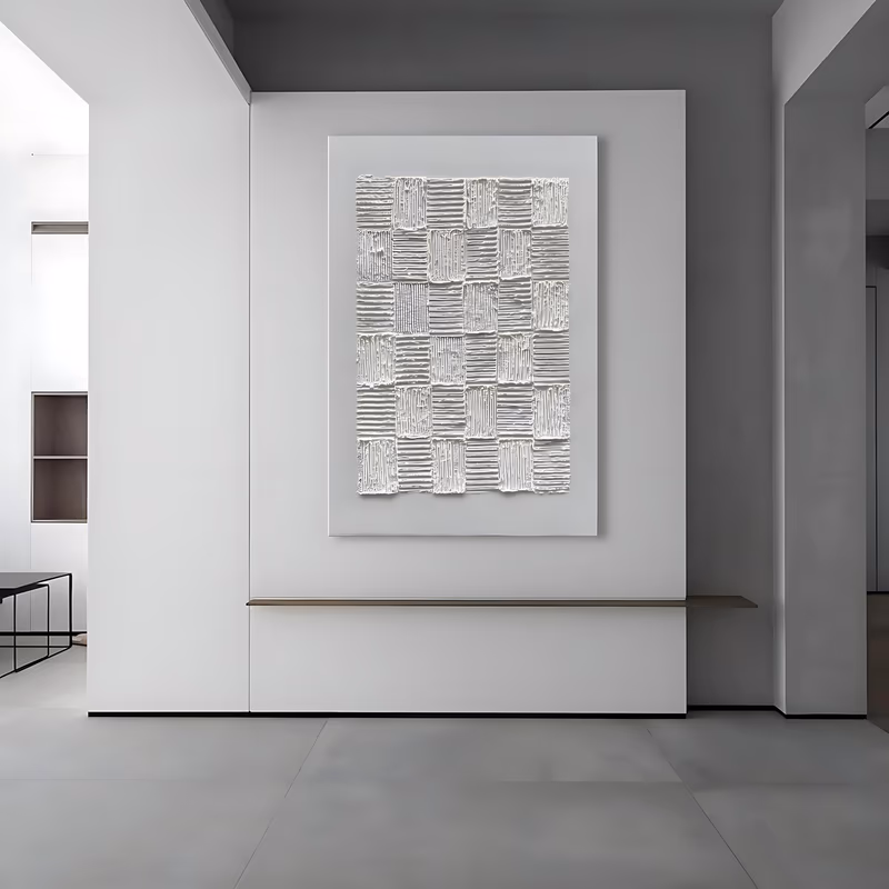 a large vertical white plaster painting of a grid of roughly cut squares, each combed with fine horizontal ridges that run in alternating directions, on an off-white canvas in heavy sculpted relief