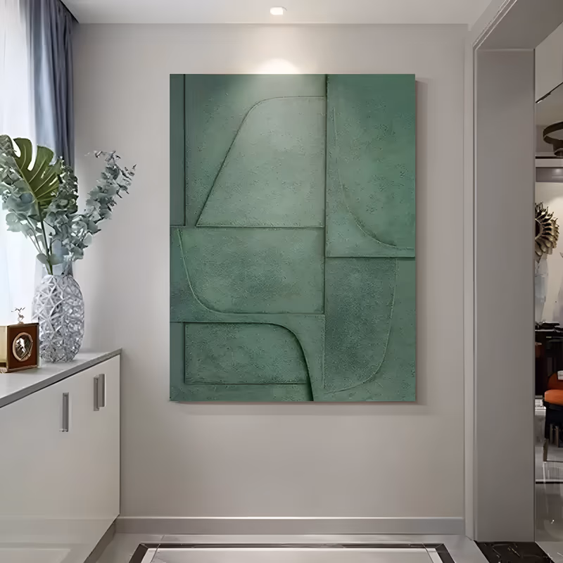 a large vertical plaster relief painting in a single sage green, its surface divided into flat panels by curved and straight raised edges that catch light along each ridge, with a chalky matte finish